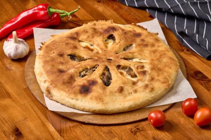 Осетинский пирог с говядиной, грибами и сыром, разрез, видна начинка
