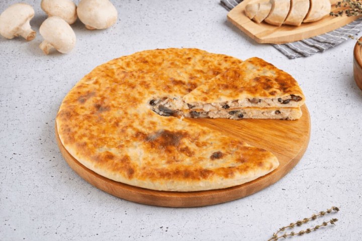 Осетинский пирог с курицей, грибами и сыром, разрез, видна начинка