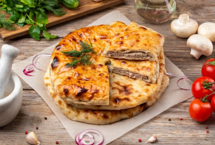 Разрезанный пирог с мясом: сектор отделён, начинка видна в разрезе