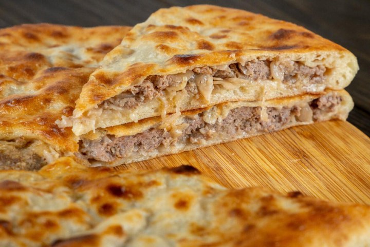 Осетинский пирог с мясом и капустой, разрез, видна начинка