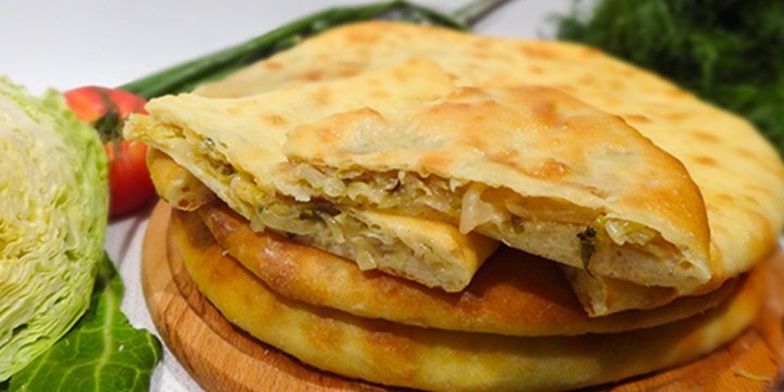 Осетинский пирог с мясом, капустой и сыром, разрез, видна начинка